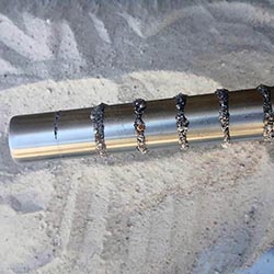 Stainless steel magnetic rod capturing fine ferrous particles and contaminants.