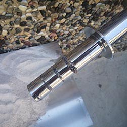 Magnetic rod extracting ferrous debris from granular material for product purity.
