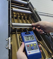 Measuring the Gauss level of a magnetic grate separator with a handheld digital meter.