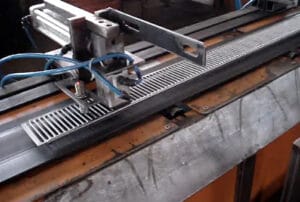 Magnetic gripper securely holding a perforated steel part in an industrial automation setup.
