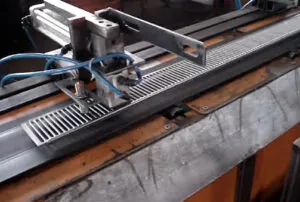 Magnetic gripper securely holding a perforated steel part in an industrial automation setup.