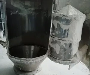 Industrial bullet magnet installed in a processing line for separating ferrous contaminants from powdered materials.