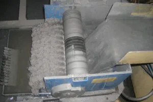 Magnetic drum extracting ferrous particles from industrial coolant.